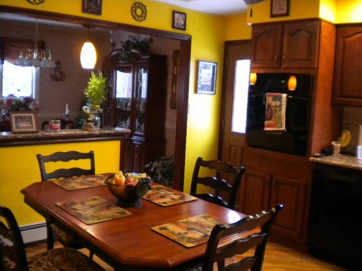 Kitchen before the work began, with yellow walls, dated cabinetry and the family's furniture still in place