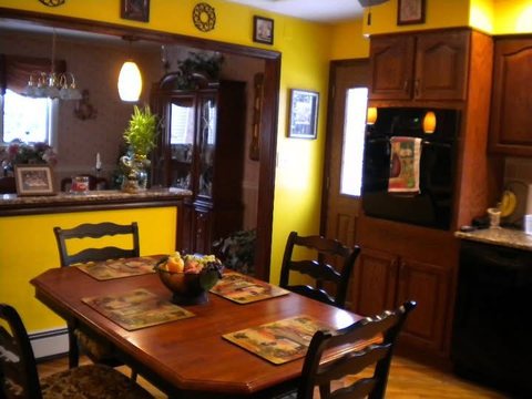Kitchen before the work began, with yellow walls, dated cabinetry and the family's furniture still in place