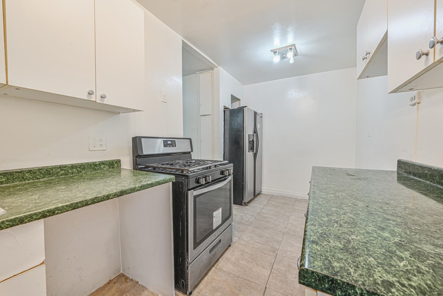 Jackson Heights co-op kitchen before renovation with outdated cabinets and nonworking appliances