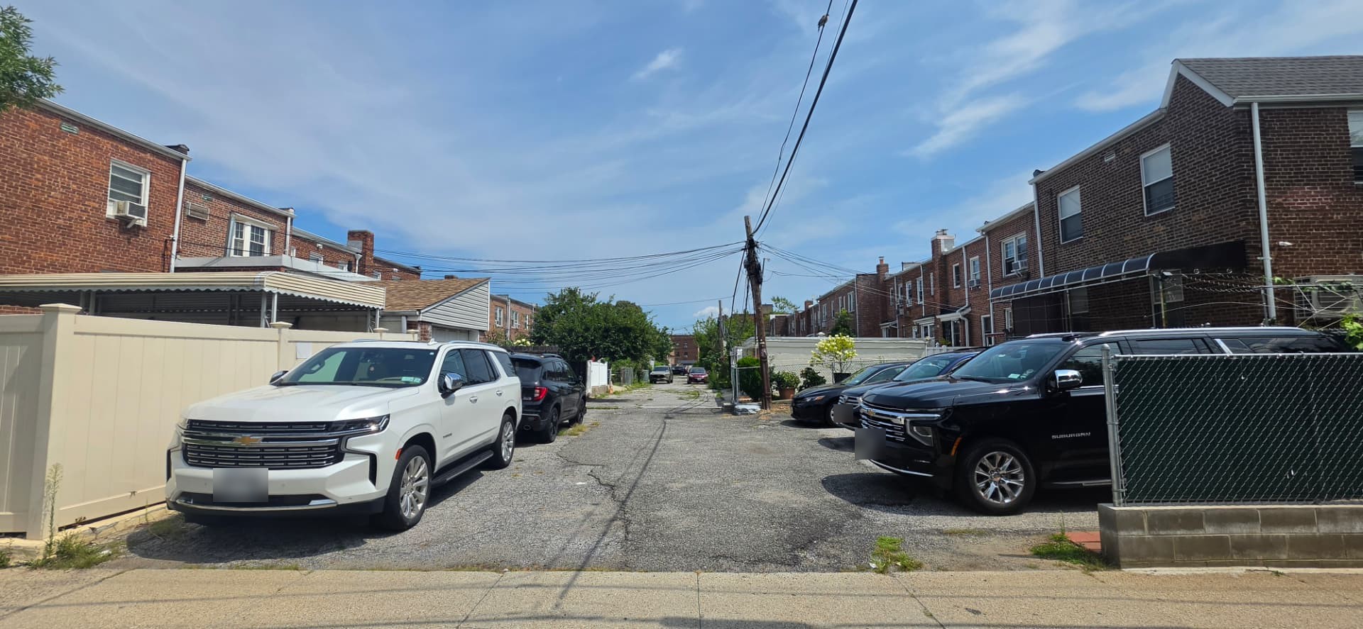 Shared rear driveway providing access behind attached homes in Bayside, Queens