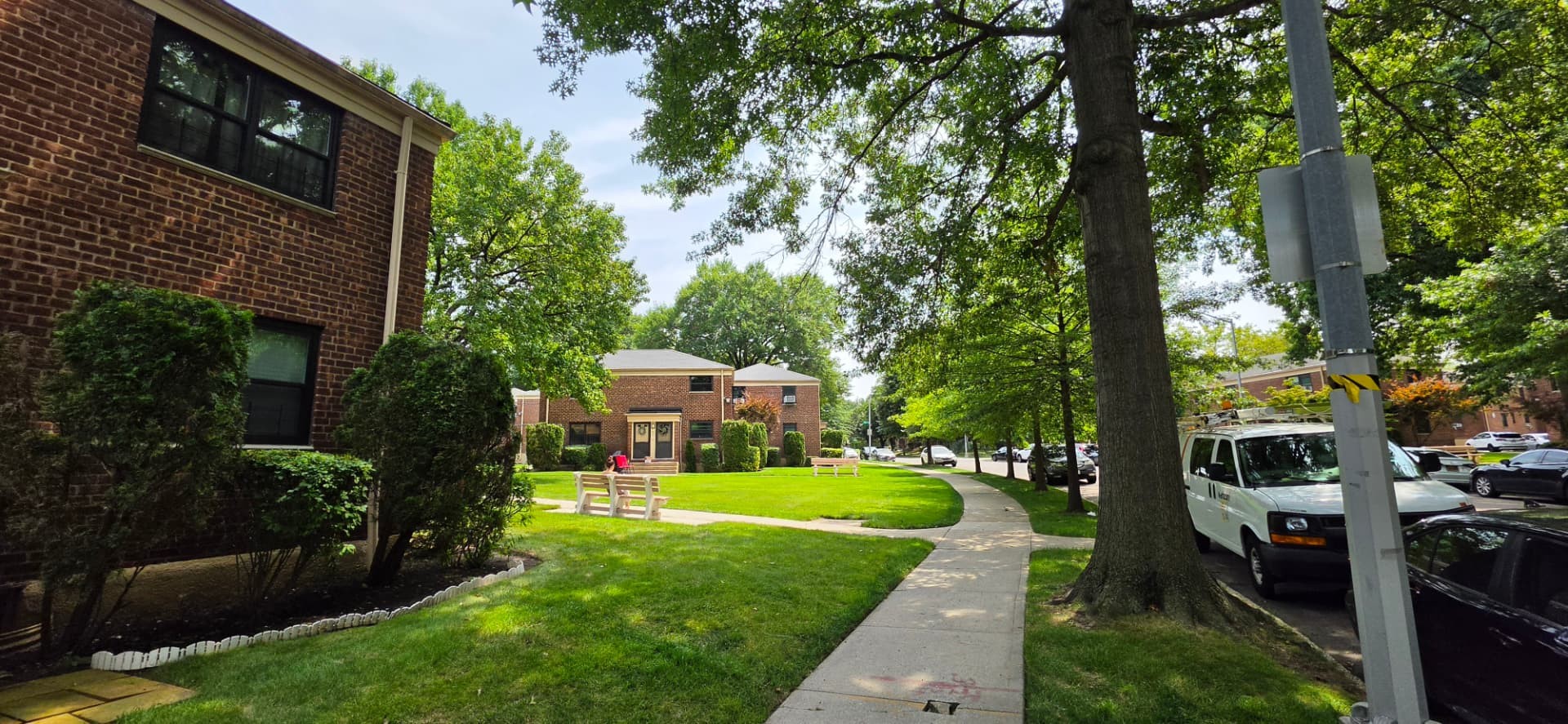 Landscaped brick co-op buildings, lawns and mature trees at Windsor Oaks in Bayside