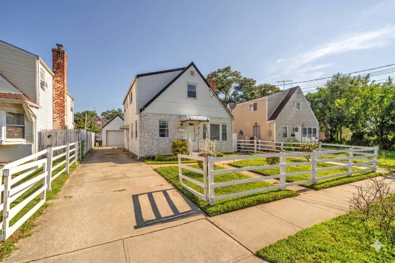 Angled exterior of 195 Alabama Avenue showing the driveway and detached garage.